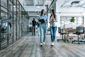 Bureaux avec des cloisons vitrées lumineux avec deux femmes qui marchent